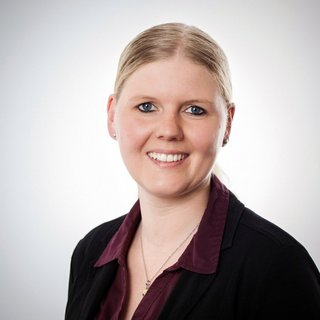 Professionelles Porträt einer lächelnden Frau mit blonden Haaren Die Frau hat eine freundliche Ausstrahlung, mit blonden Haaren und blauen Augen, die in die Kamera lächelt.