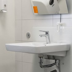 Ein modernes Waschbecken mit einem glänzenden Wasserhahn in einem hellen, sauberen Badezimmer.