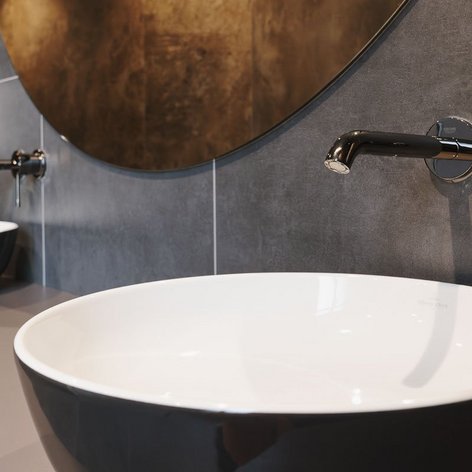 Zwei moderne Waschbecken mit eleganten schwarzen und weißen Designs, umgeben von stilvollen grauen Wänden.