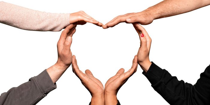 Fünf Hände formen gemeinsam ein Herz, das eine Botschaft von Liebe und Zusammenhalt symbolisiert.