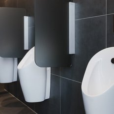 Drei moderne Urinale in einem stilvollen, dunklen Badezimmer mit eleganten Trennwänden und minimalistischer Ausstattung.