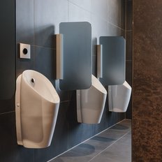 Drei moderne Urinale in einem stilvollen, dunklen Badezimmer mit eleganten Wänden und einem Fenster im Hintergrund.