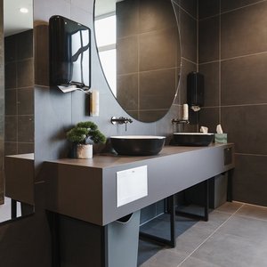 Ein modernes Badezimmer mit zwei eleganten Waschbecken, einem großen Spiegel und stilvollen schwarzen Handtuchhaltern.
