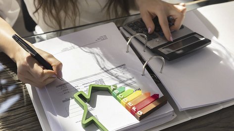 Ein Ordner auf dem ein Taschenrechner und ein Energieverbrauch zeichen liegt